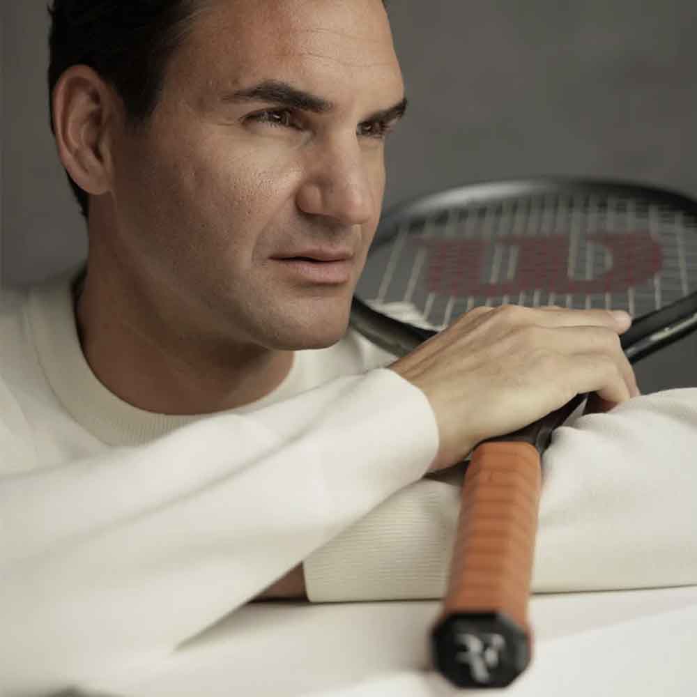 Roger Federer segurando uma raquete de tênis e, no detalhe Cushion Grip Wilson RF Premium.